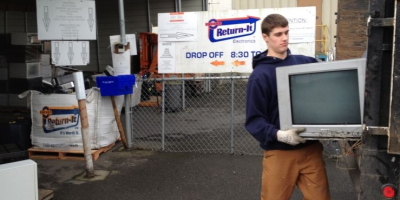 Feller loading tv into junk truck