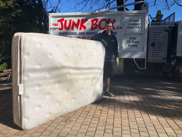 Old mattress getting loaded into truck