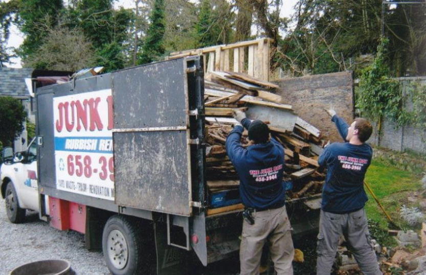 men loading debris into truck